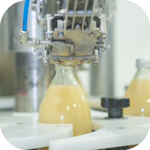 Bouteille en verre de nectar de poire de couleur jaune pâle 1L de face embouteillage -  Juste le Choix du Fruit