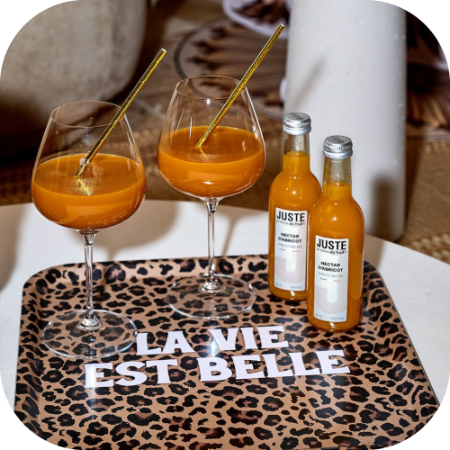 Bouteille en verre de nectar d'abricot 25 cl sur un plateau imprimé léopard et deux verres -  Juste le Choix du Fruit